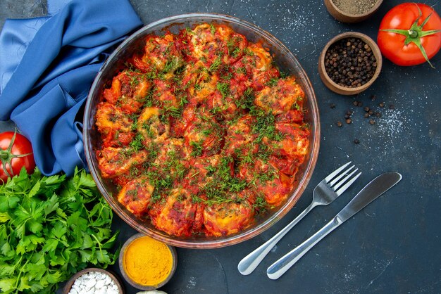 Vista superior de sabrosas verduras cocidas con condimentos y verduras en la mesa azul plato comida carne cocina comida sabor familiar