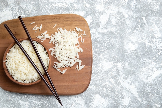 Foto gratuita vista superior sabroso arroz cocido dentro de la placa marrón sobre blanco claro