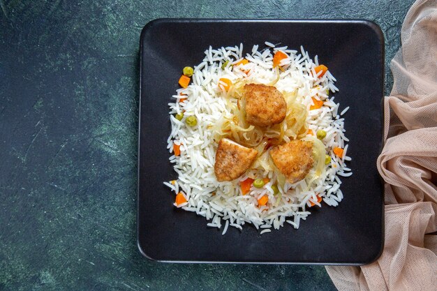 Vista superior sabroso arroz hervido con frijoles y carne dentro de la placa en el escritorio oscuro