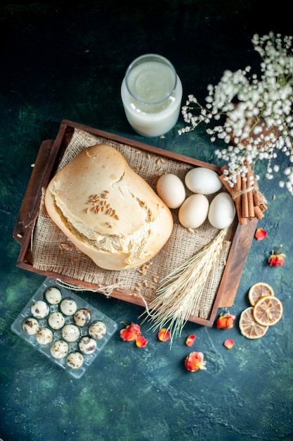 Vista superior sabroso pan fresco con huevos y leche sobre fondo oscuro pastel pastel té azúcar bollo hornear galletas masa para el desayuno