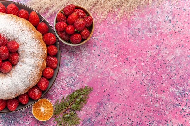 Vista superior sabroso pastel de fresa con azúcar en polvo en rosa claro