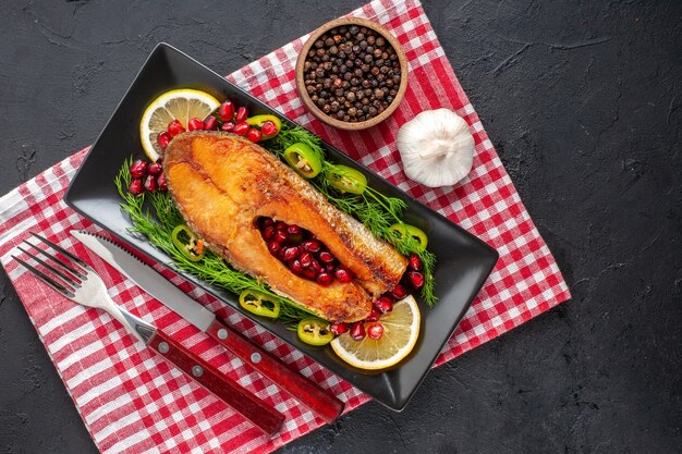 Foto gratuita vista superior sabroso pescado cocido con limón y verduras en la mesa oscura