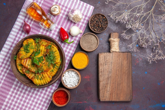 Vista superior sabroso plato delicioso de patatas cocidas con verduras y condimentos en la superficie oscura cena cocinando comida plato de patata