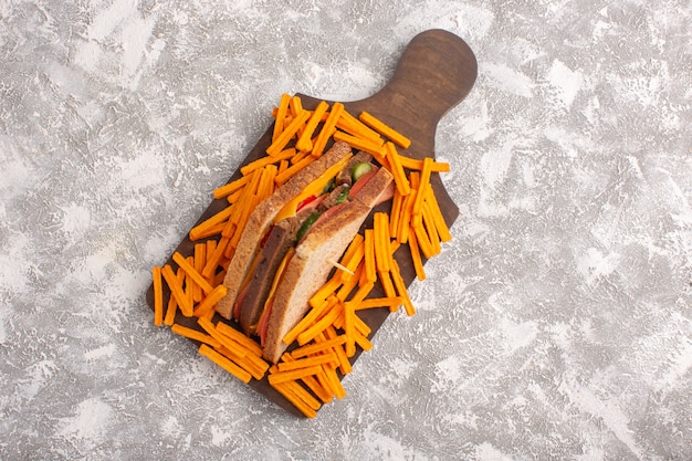 Vista superior sabroso sándwich de tostadas con jamón de queso junto con papas fritas en la comida de sándwich de fondo blanco