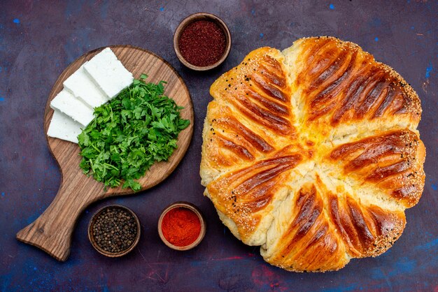 Vista superior de sabrosos pasteles horneados con verduras y queso blanco sobre la superficie oscura