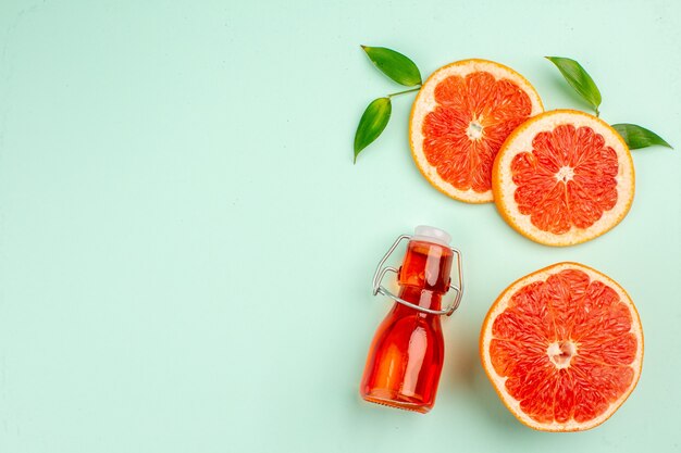 Vista superior de sabrosos pomelos en rodajas jugosas en la superficie azul claro