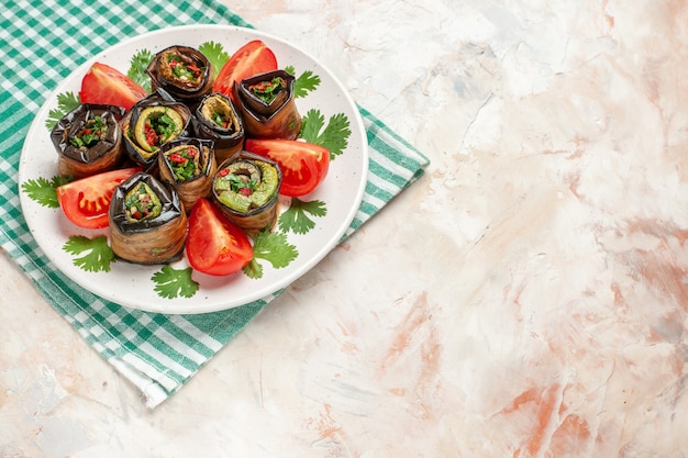 Vista superior de sabrosos rollos de berenjena con tomates y verduras