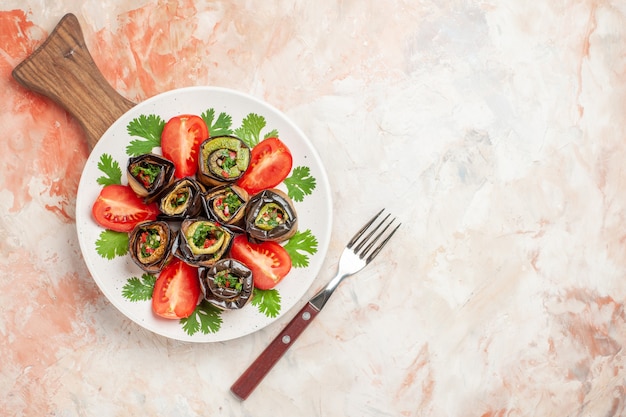 Foto gratuita vista superior de sabrosos rollos de berenjena con tomates