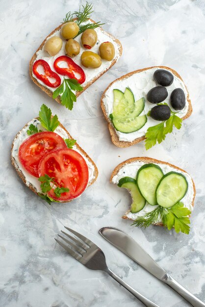 Vista superior sabrosos sándwiches con pepinos y aceitunas sobre fondo blanco hamburguesa tostadas almuerzo comida horizontal pan comida