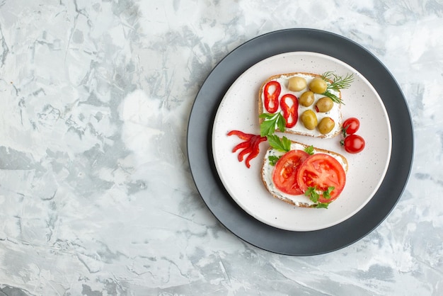 Vista superior sabrosos sándwiches con tomates y aceitunas fondo blanco pan comida almuerzo comida horizontal tostadas hamburguesa sándwich espacio libre