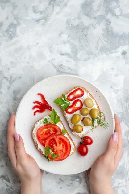 Vista superior sabrosos sándwiches con tomates y aceitunas sobre fondo blanco comida comida saludable pan almuerzo tostadas horizontales hamburguesas