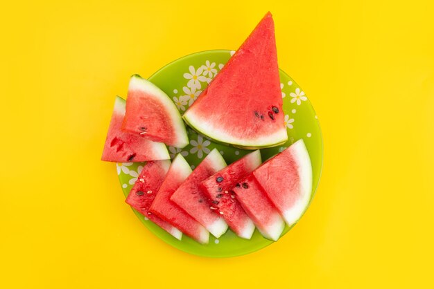 Una vista superior de sandía fresca en rodajas jugosa y suave en el escritorio amarillo, color de verano de frutas