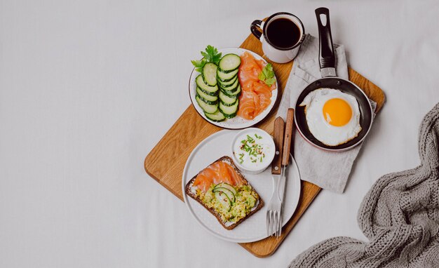 Vista superior de sándwiches de desayuno en la cama con huevo frito y espacio de copia