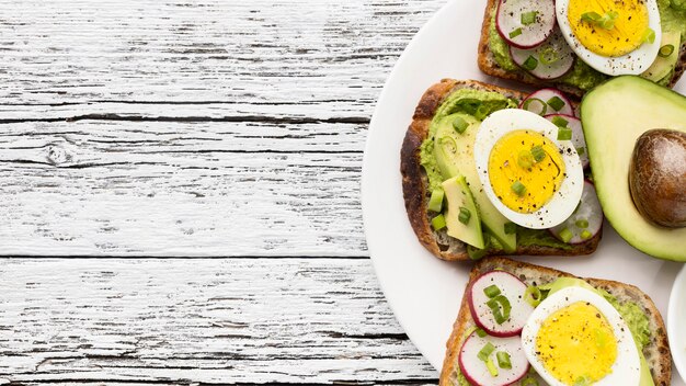 Vista superior de sándwiches de huevo y aguacate en un plato con espacio de copia