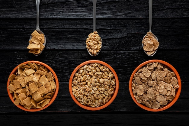 Vista superior de la selección de cereales para el desayuno en tazones con cucharas