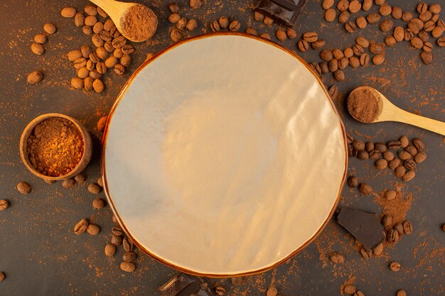 Una vista superior de semillas de café marrón con barras de chocolate en todo el gránulo de grano de semilla de café de fondo marrón