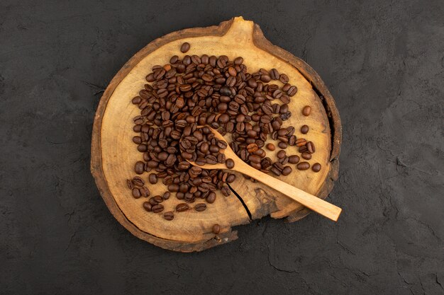 Vista superior de semillas de café marrón en el piso oscuro