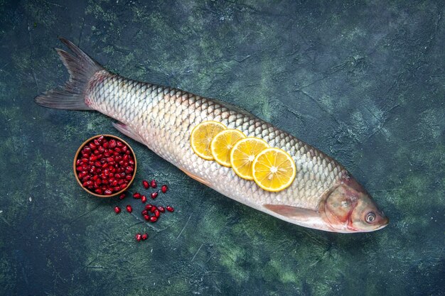 Vista superior de semillas de granadas de pescado crudo en un recipiente en la mesa con espacio libre