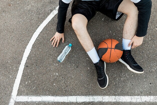 Vista superior sentado hombre con baloncesto