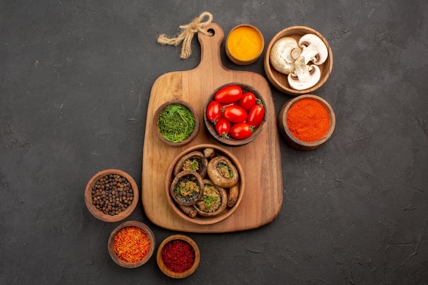 Vista superior de setas cocidas con condimentos en mesa oscura comida madura salvaje