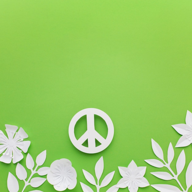 Vista superior del signo de la paz de papel con hojas