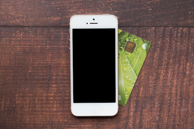 Vista superior smartphone con tarjeta de crédito