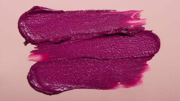 Vista superior sombra de lápiz labial púrpura sobre fondo rosa