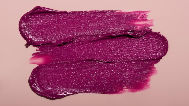Vista superior sombra de lápiz labial púrpura sobre fondo rosa