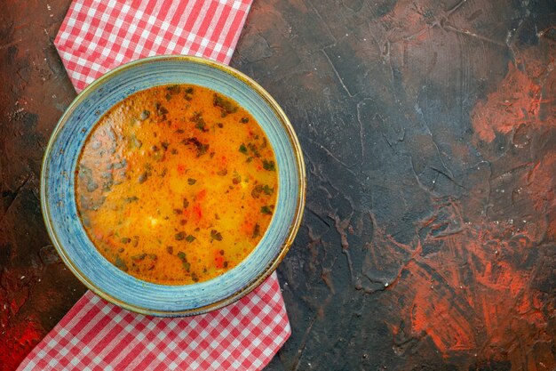 Foto gratuita vista superior de la sopa de arroz en un tazón sobre un mantel a cuadros rojo blanco sobre fondo