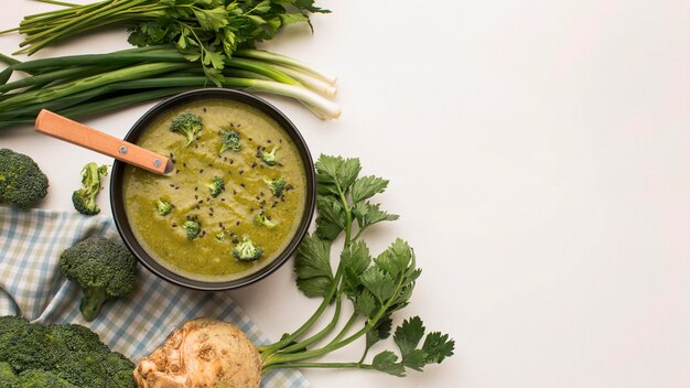 Vista superior de la sopa de brócoli de invierno en un tazón con apio y espacio de copia