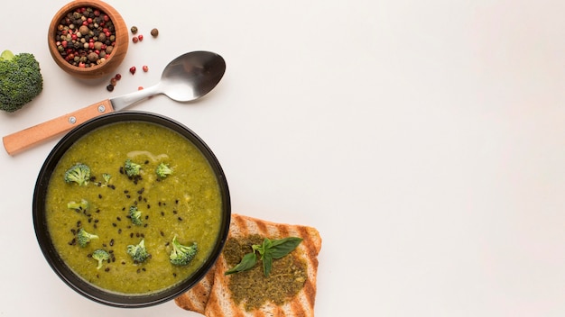 Foto gratuita vista superior de la sopa de brócoli de invierno en un tazón con tostadas y copie el espacio