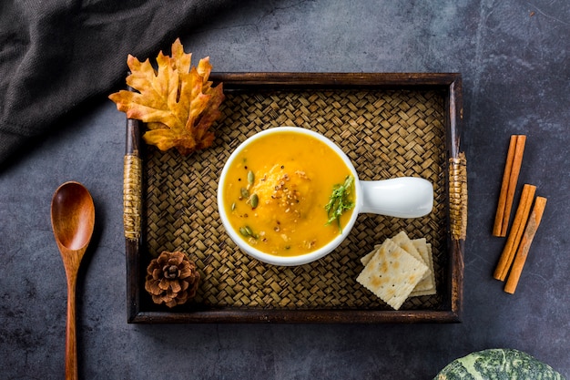 Vista superior de sopa de calabaza en bandeja de madera