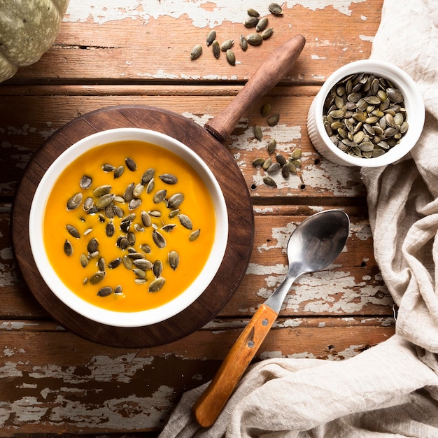 Foto gratuita vista superior de la sopa de calabaza de otoño con semillas y cuchara