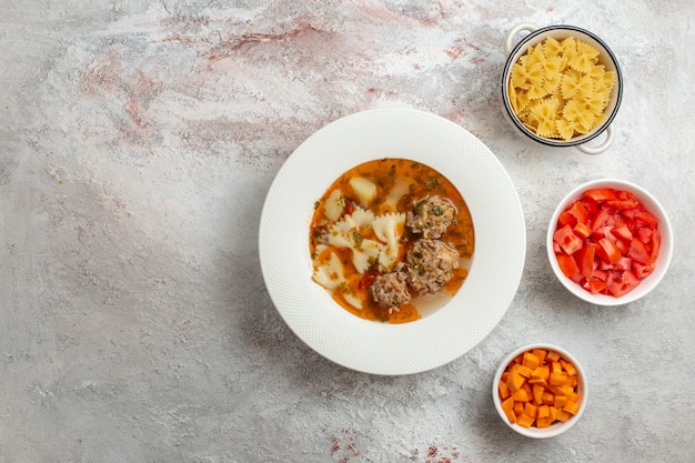 Vista superior de la sopa con carne deliciosa sopa con pimiento en rodajas sobre fondo blanco.