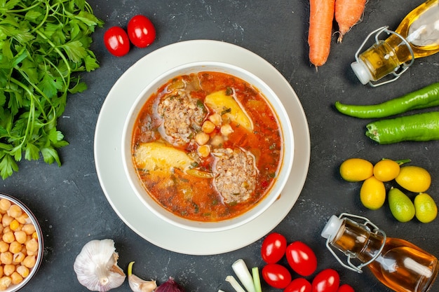 Vista superior de la sopa de carne con verduras y verduras sobre fondo gris oscuro