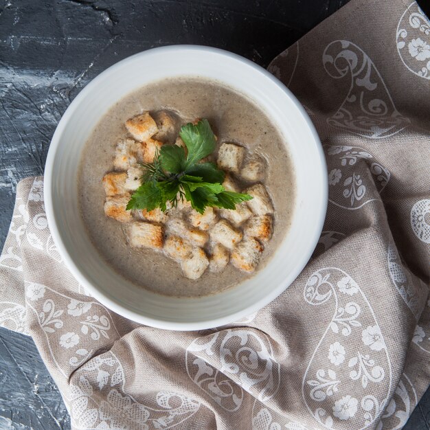 Vista superior sopa de champiñones con galletas y servilletas