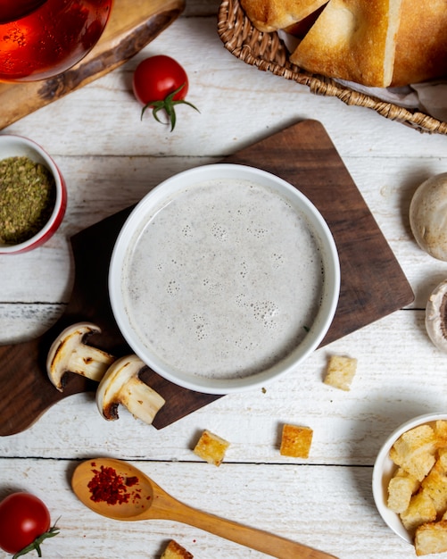 Vista superior de sopa de champiñones servida sobre tabla de madera