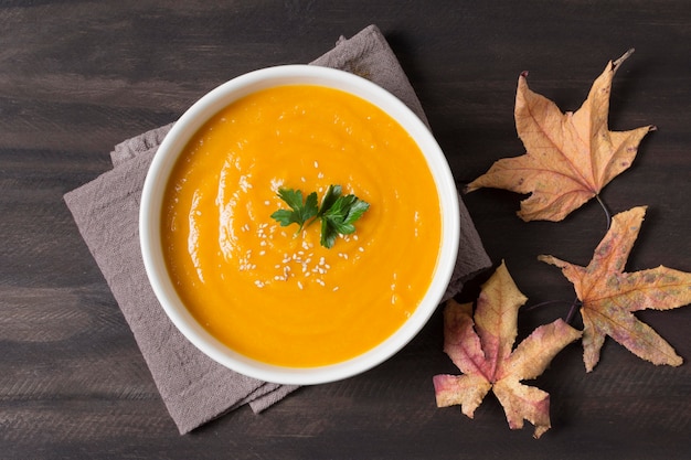 Vista superior de la sopa de crema y hojas de otoño