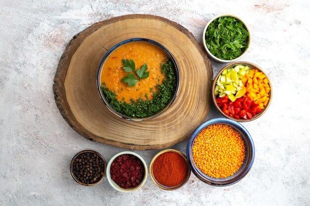 Vista superior de la sopa de frijoles con verduras y condimentos en la superficie blanca sopa comida comida vegetal
