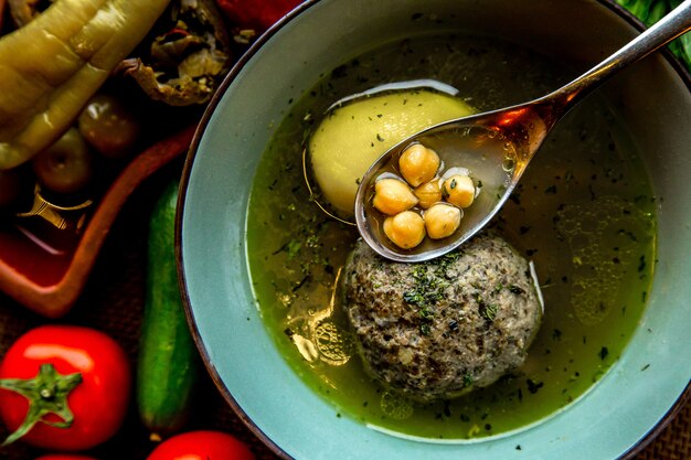 Vista superior sopa kufta-bozbash sopa azerbaiyana tradicional servida con tomates y verduras saladas