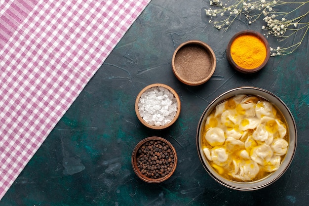 Vista superior de la sopa de masa con diferentes condimentos y verduras sobre fondo azul oscuro, ingredientes, sopa, comida, masa, cena, salsa