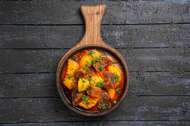 Foto gratuita vista superior de la sopa de salsa de carne con patatas y verduras en el escritorio oscuro