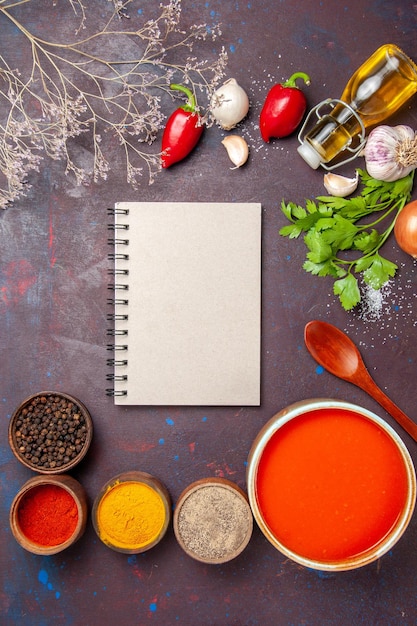 Foto gratuita vista superior de la sopa de tomate cocinada con tomates frescos con diferentes condimentos en negro