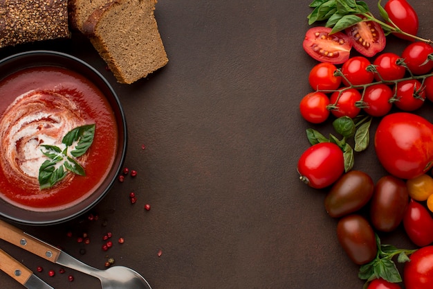 Foto gratuita vista superior de la sopa de tomate de invierno en un tazón con tostadas y cucharas