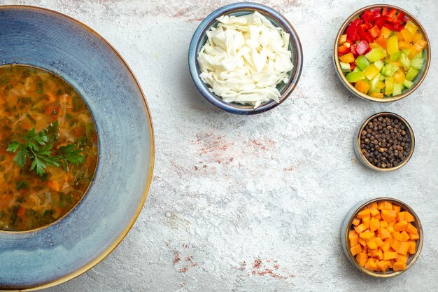 Vista superior sopa de verduras caliente con verduras en rodajas en el espacio en blanco