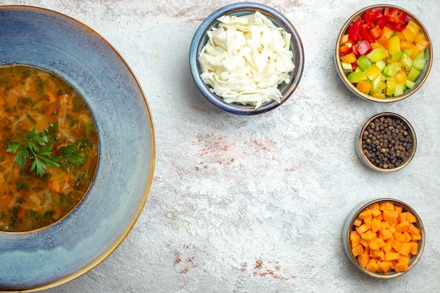 Vista superior sopa de verduras caliente con verduras en rodajas en el espacio en blanco