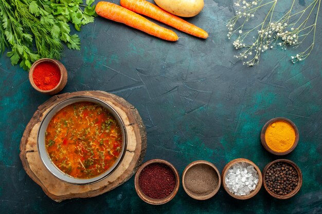 Vista superior de sopa de verduras con condimentos sobre fondo verde oscuro ingrediente sopa comida comida vegetal