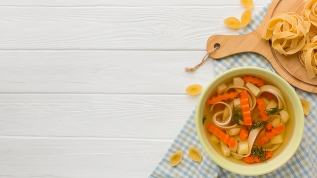 Vista superior de sopa de verduras de invierno con tagliatelle y espacio de copia