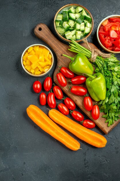 Vista superior del soporte para platos con verduras encima y cerca sobre fondo gris oscuro