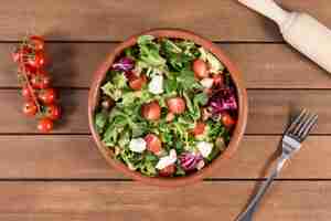 Foto gratuita vista superior de superficie de madera con ensalada deliciosa